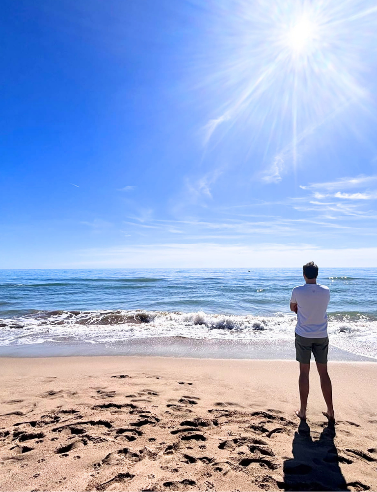 Damien Carbonnier mirando al mar en la orilla, retiros de ayuno Mi Ayuno